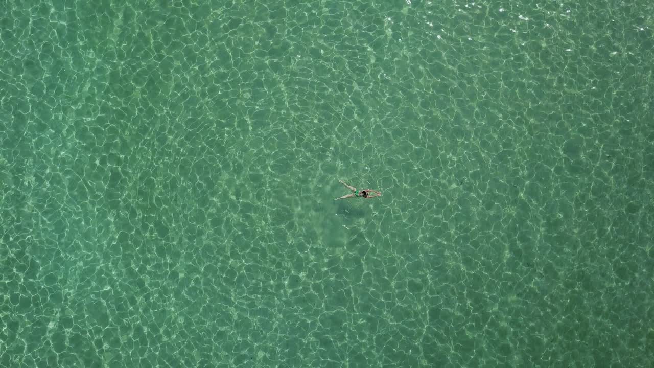 mujer turista flota y nada en las claras aguas verdes del mar egeo