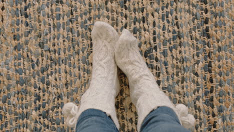 pies de vista superior con calcetines cómodos disfrutando del calor en casa sobre una alfombra