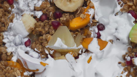 yogurt pouring granola fruits super slow motion closeup. cereal flakes with milk