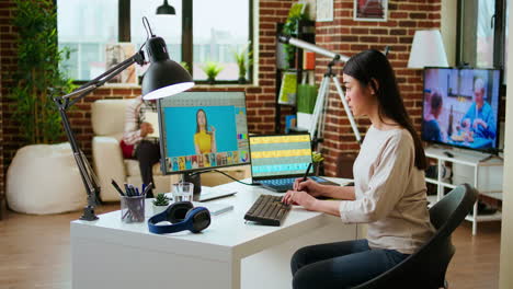 expert artist woman edits digital photos on her computer in a creative office