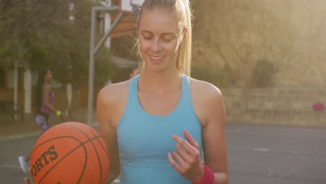 Porträt-Einer-Kaukasischen-Basketballspielerin,-Die-Den-Ball-Hält-Und-In-Die-Kamera-Blickt