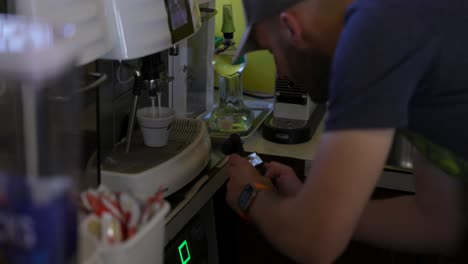vlogger grabando un video de la máquina de café haciendo capuchino con dji osmo bolsillo 3 estabilizado pequeña cámara móvil