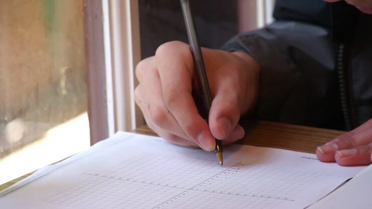 Student Writing on Graph Paper Close Up