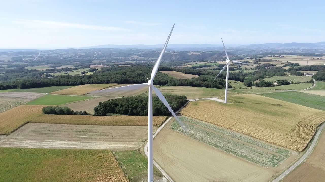 Drone shot of two windmills on farmland with beautiful landscape