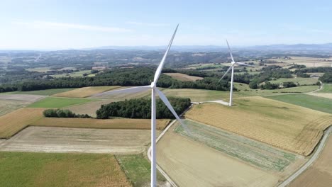 Drohnenaufnahme-Von-Zwei-Windmühlen-Auf-Ackerland-Mit-Wunderschöner-Landschaft