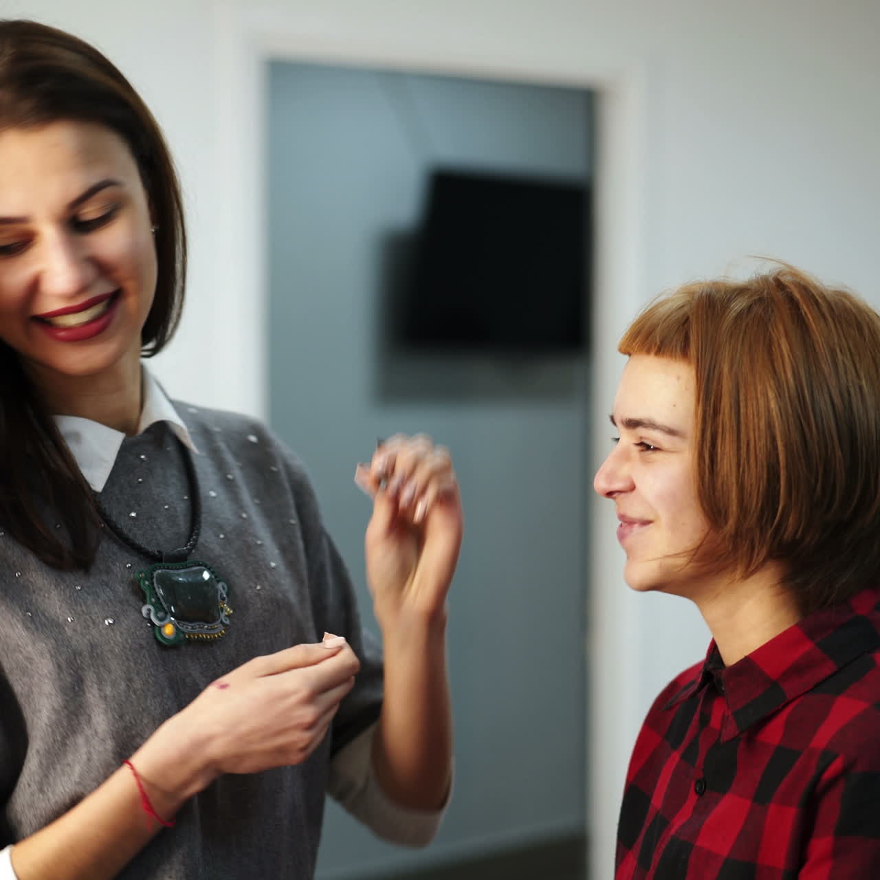 Professional makeup artist working with beautiful young woman. Process of making makeup.