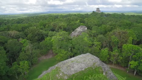 spectacular aerial shot over the treetops and tikal pyramids in guatemala 1