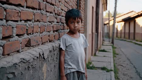 child standing near a brick wall