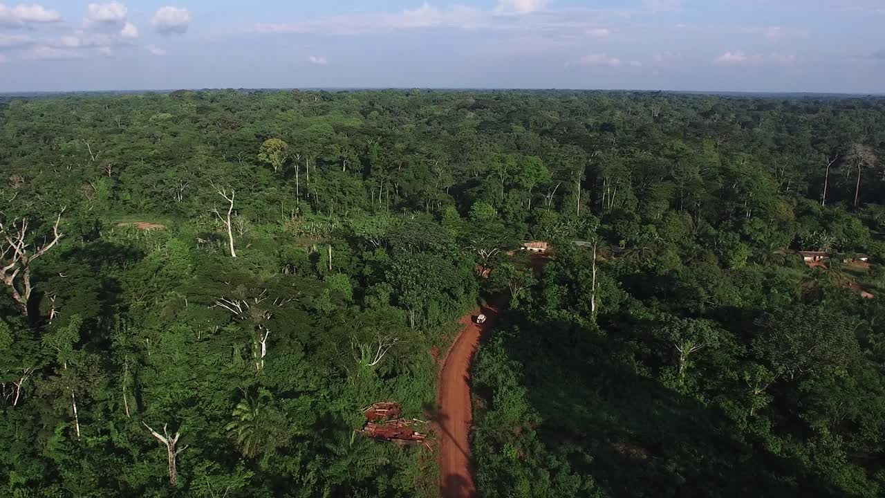 disparo de drones rastreando un jeep conduciendo en una ruta distante en la jungla en camerún, áfrica