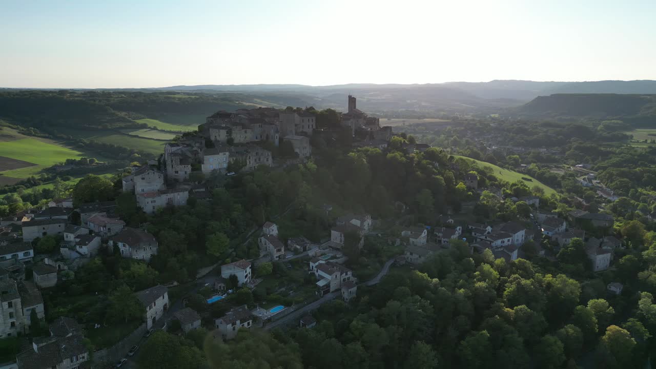 Drone aerial view in France countryside small old medieval brick town on a mountain top circling around on a sunny day in Cordes Sur Ciel
