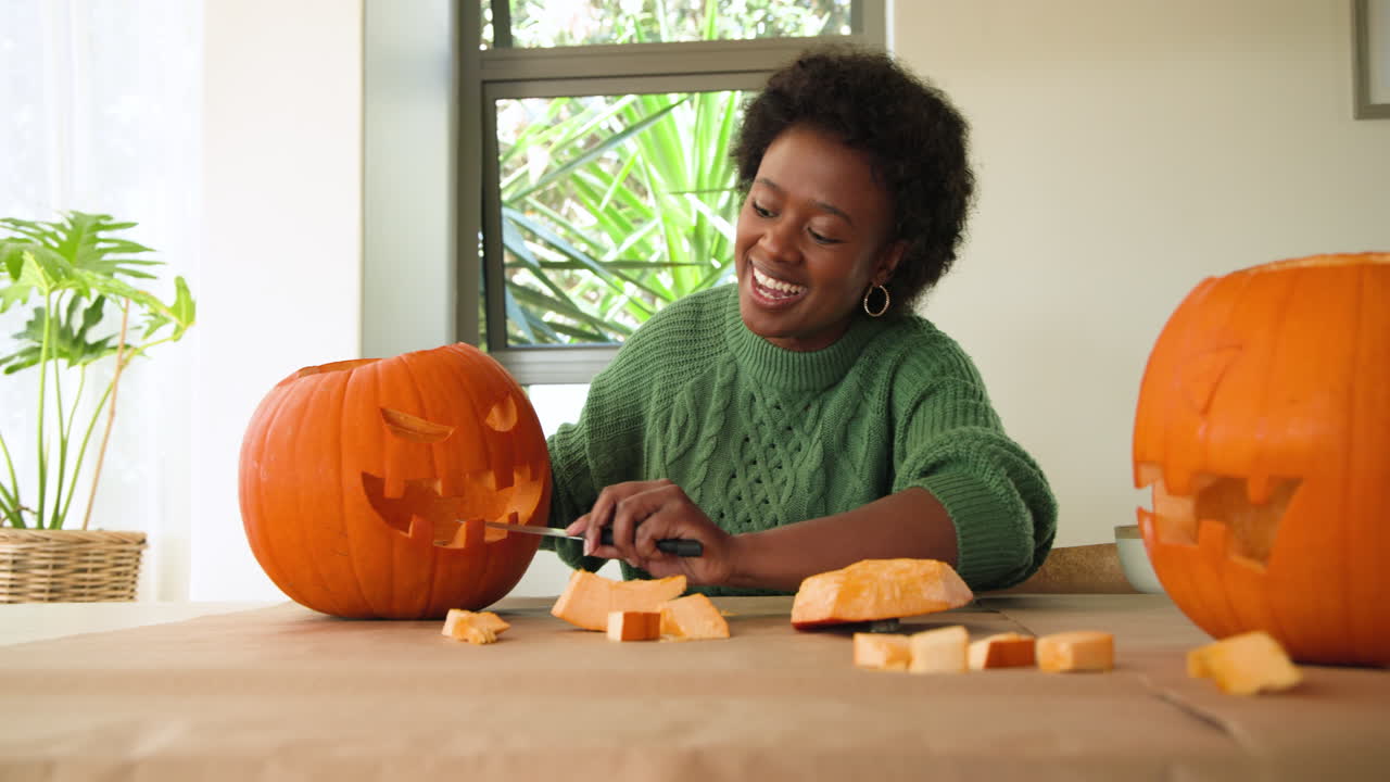 Carving pumpkin at home, woman smiling and enjoying creative seasonal activity