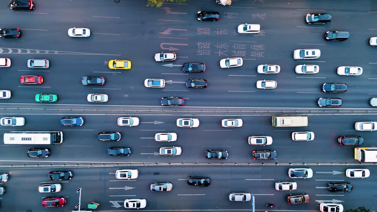 Drone shot of rush hour traffic in Guangzhou, China, a busy city road filled with a variety of cars moving in both directions.