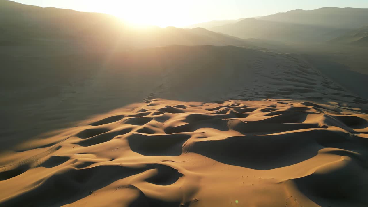 Expansive aerial footage of the Atacama Desert dunes at sunset, showing sweeping lines and soft shadows