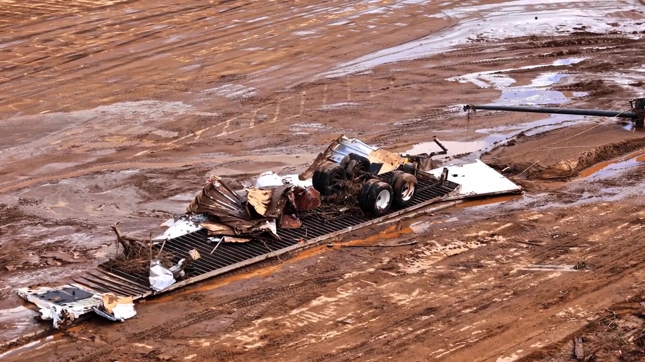 Drone pans across crushed semi trailer, destroyed by the Hurricane Helene flooding.