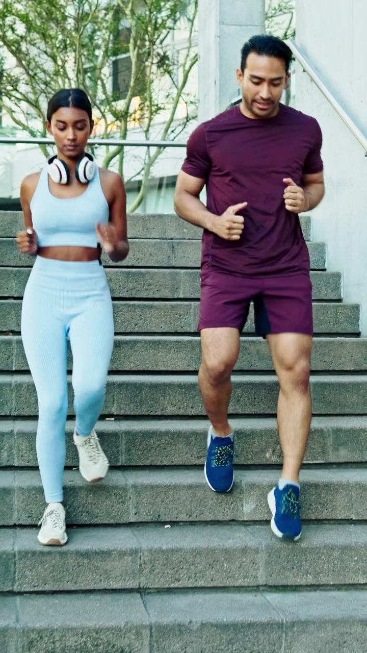 Giovane coppia che fa jogging su una scalinata esterna in cemento