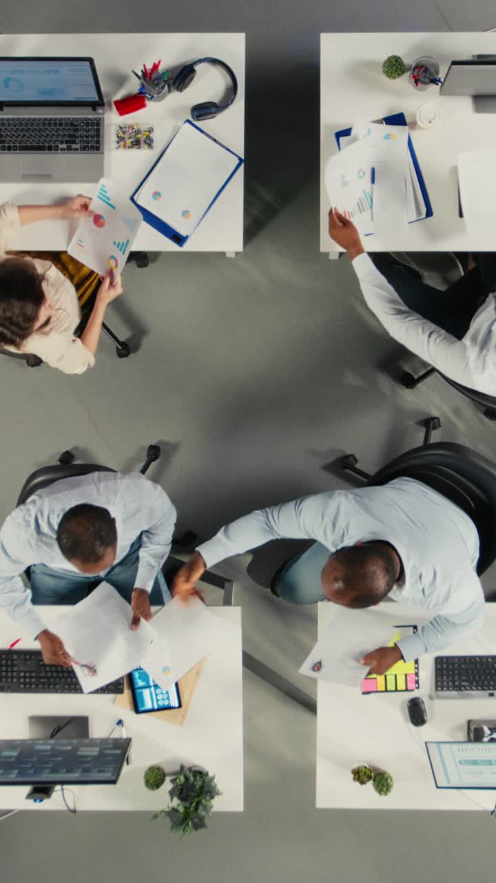 Vertical Video Top down view zoom in of corporate workers assessing business objectives