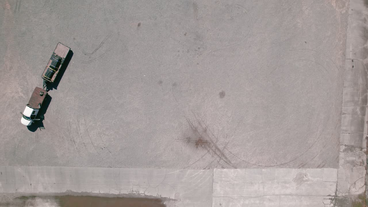 큰 빈 주차장에서 프레임 픽업 트럭을 들어오고 있습니다.