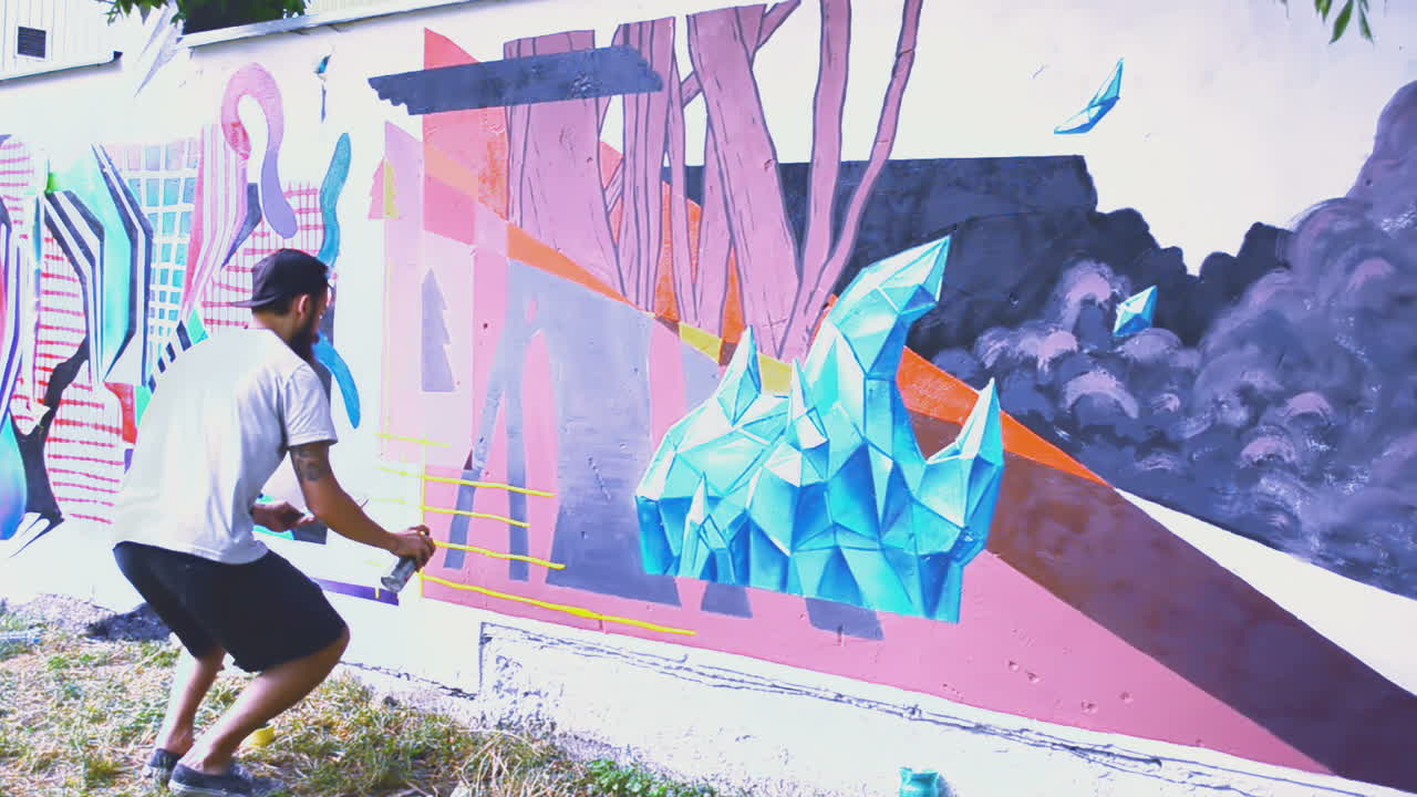L'artista realizza graffiti su una recinzione. Disegno astratto