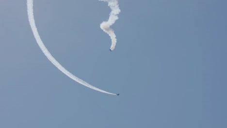 dos aviones de acrobacia, uno en una cabina en espiral, y uno dando vueltas a su alrededor