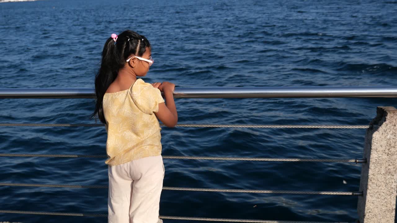 Girl on a pier looking at the sea
