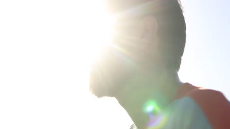 looking up closeup follow shot of a male trail runner backlit with sun behind seen from the side profile