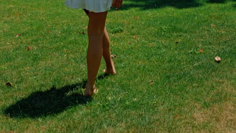 woman walking barefoot in a grassy garden
