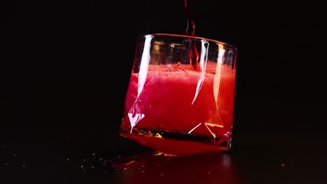 red drink poured into tilted glass