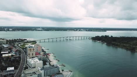 aerial view of causeway bridge and hotels in clearwater, florida, dark clouds, backward