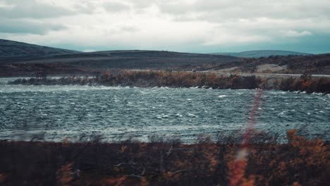 strong wind raising waves and blowing the water off the surface of the lake