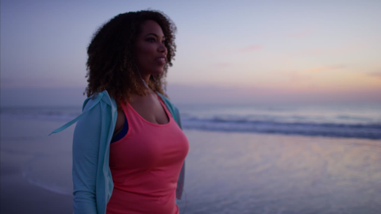 mujer étnica voluptuosa haciendo ejercicio suave en la playa