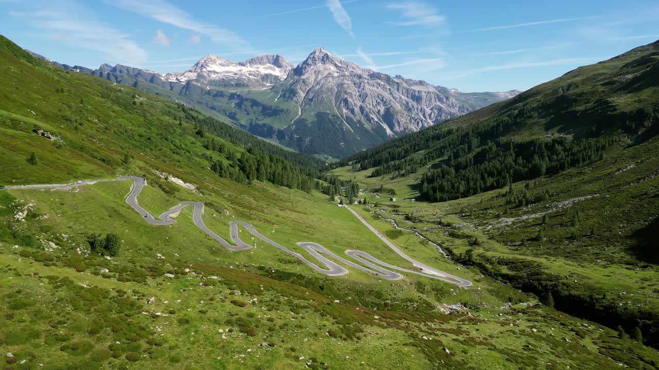 una impresionante vista de avión no tripulado del paso de splügen, que muestra una carretera sinuosa que serpentea a través de majestuosas montañas