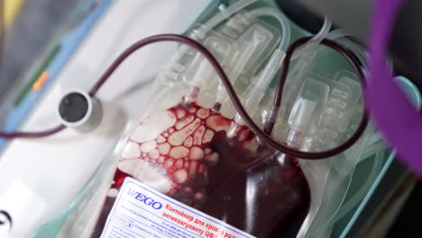 container with blood sample in the plastic bag. close up. blood is mixed with coagulant.