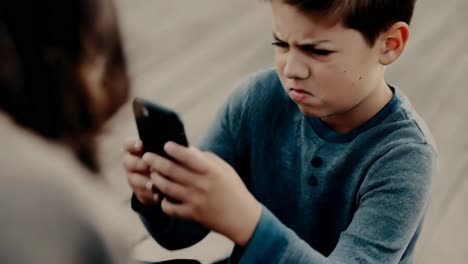 boy upset while looking at a smartphone