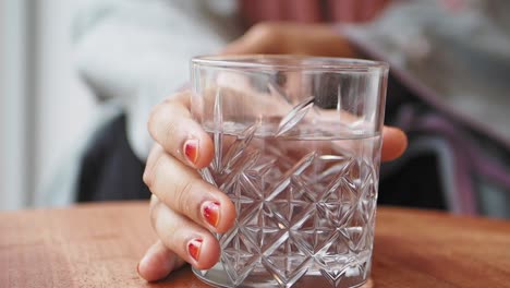 mujer sosteniendo un vaso de agua