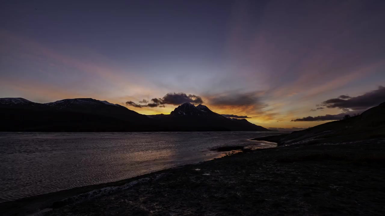 Um lapso de tempo do pôr do sol às 13h com navios passando no norte da Noruega. Capturado em Andstraumsneset na ilha Kvaløya, nos arredores de Tromsø