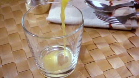 orange juice pouring into a glass, the morning breakfast. slow motion with rotation tracking shot.