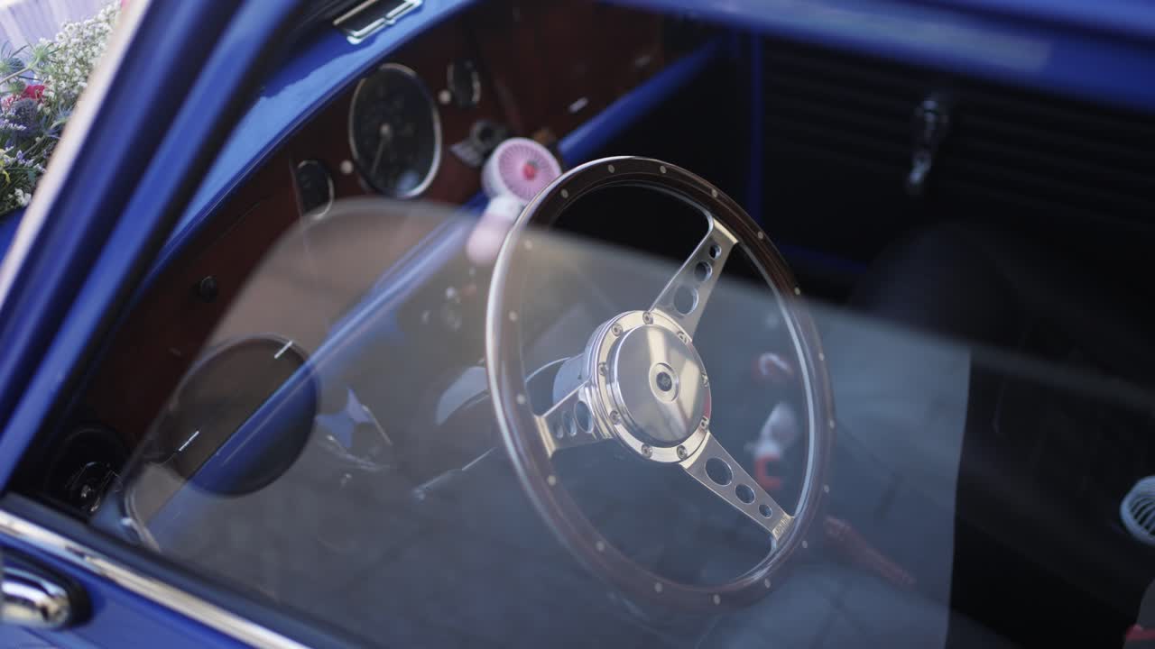 vintage Mini Cooper’s interior, featuring a wooden dashboard and chrome steering wheel