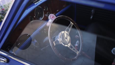 vintage mini cooper’s interior, featuring a wooden dashboard and chrome steering wheel