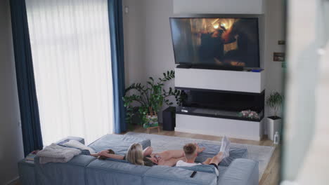 couple relaxing on couch watching tv