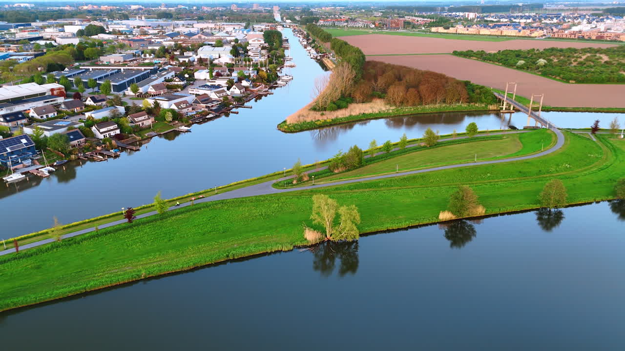 Scenery of beautiful village and stunning nature of the Netherlands. Countryside with canals and fields. Aerial view.
