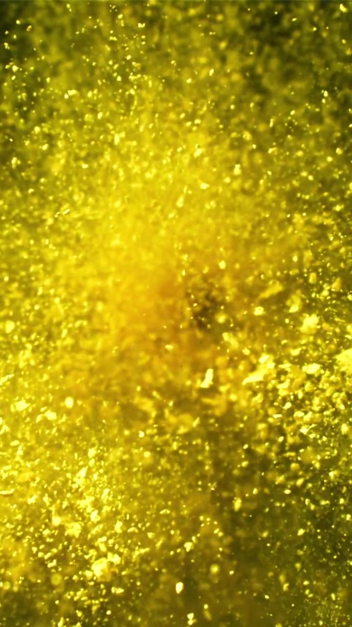 Particelle vibranti gialle e dorate che scintillano in un liquido astratto