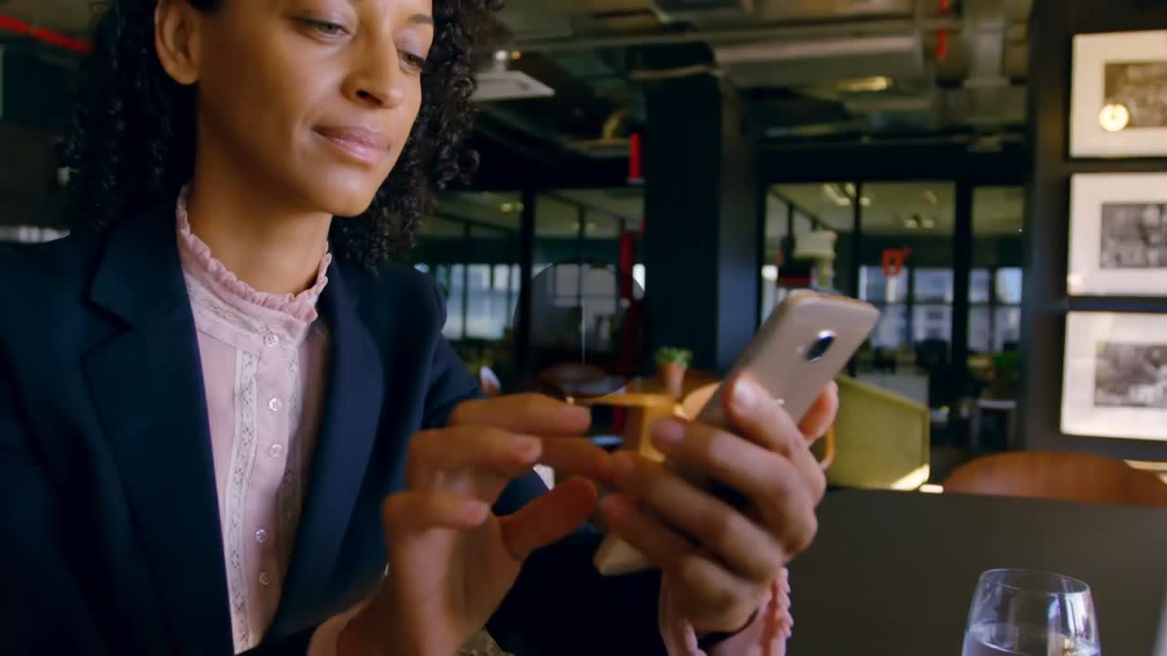 Animation of network of connections with media icons over biracial woman using smartphone