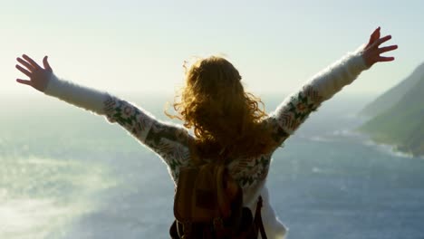 woman standing with arms outstretched near a sea 4k