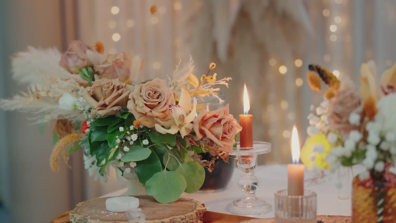 elegant table setting with beige roses greenery and candles glowing in warm ambient light
