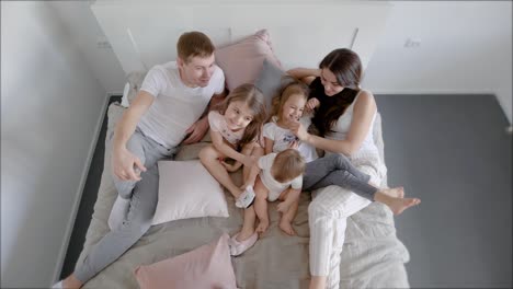 family lying in bed in morning with kids