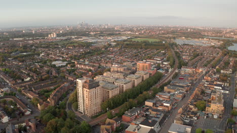 aerial shot over walthamstow looking towards central london at golden hour