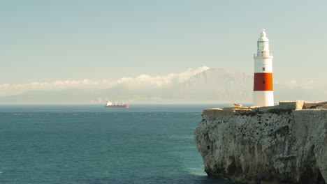 Schöner-Leuchtturm-Und-Frachtschiff-Im-Hintergrund,-Zeitraffer