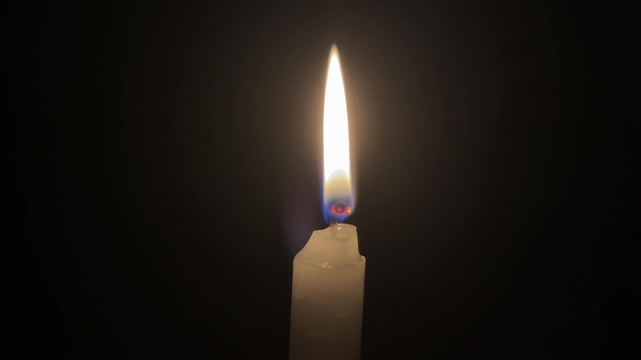 Flamme de bougie éclatante sur fond noir
