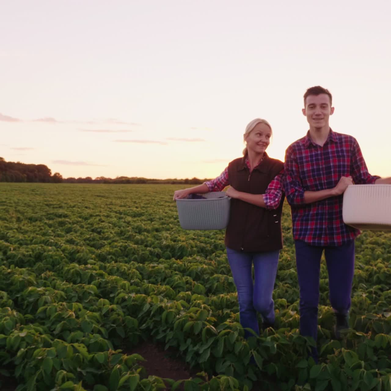 dos granjeros de la jaula en sus manos caminan por el campo 1