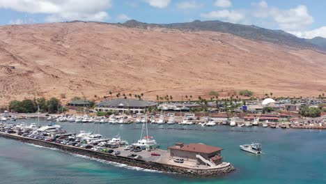 Low-aerial-panning-shot-of-a-boat-entering-the-Maalaea-Harbor-in-West-Maui,-Hawai'i